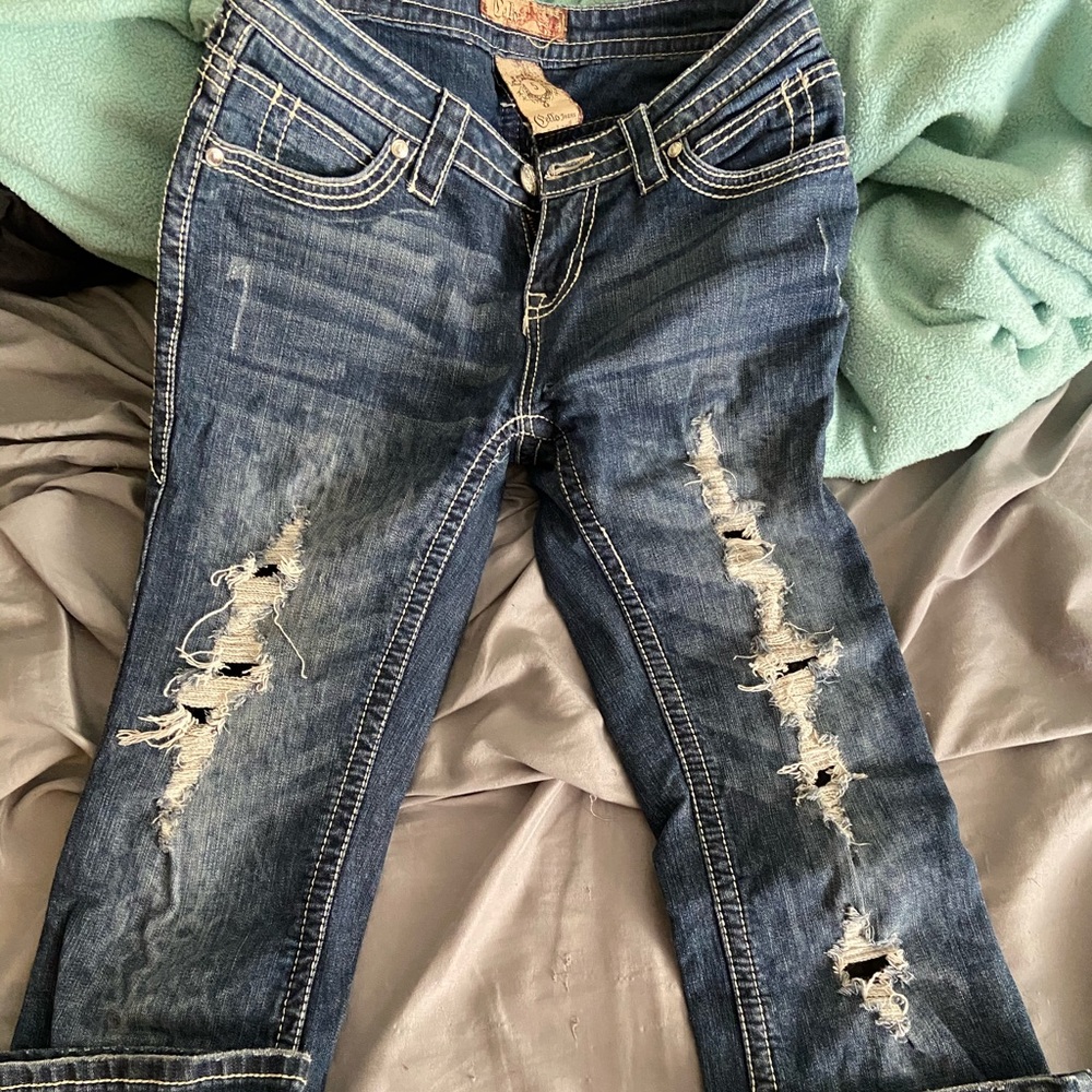 Women’s cello jeans has lace where the holes are.